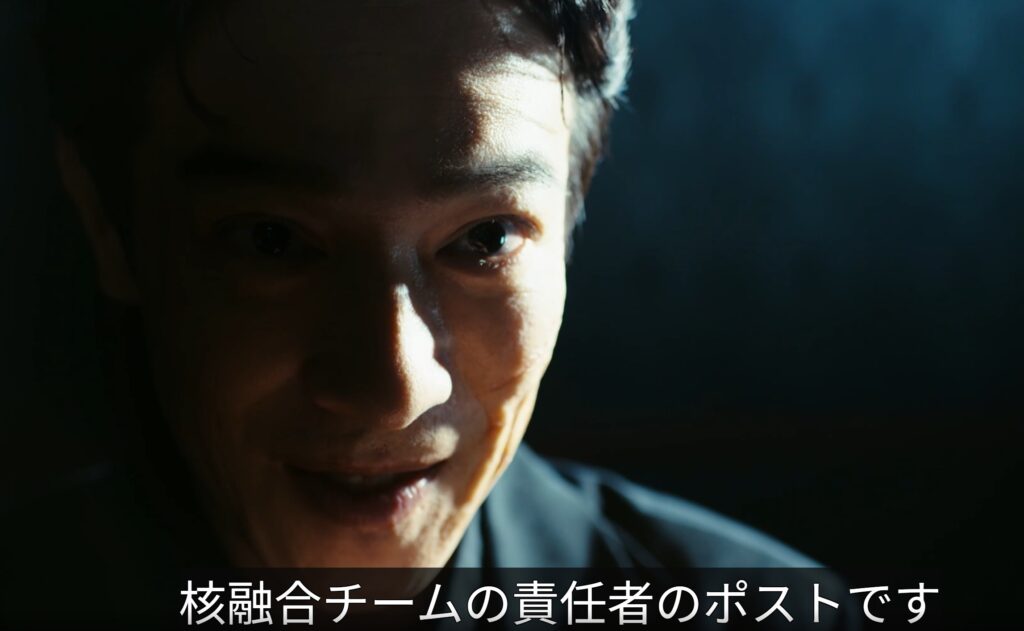 ドラマ『VIVANT』の堺雅人(乃木憂助)が暗闇の中でスポットライトを浴び、アップで不敵な笑みを浮かべている。下部に「核融合チームの責任者のポストです」という白い字幕。テントの情報をエサに核融合チームの責任者ポストを要求するシーン。