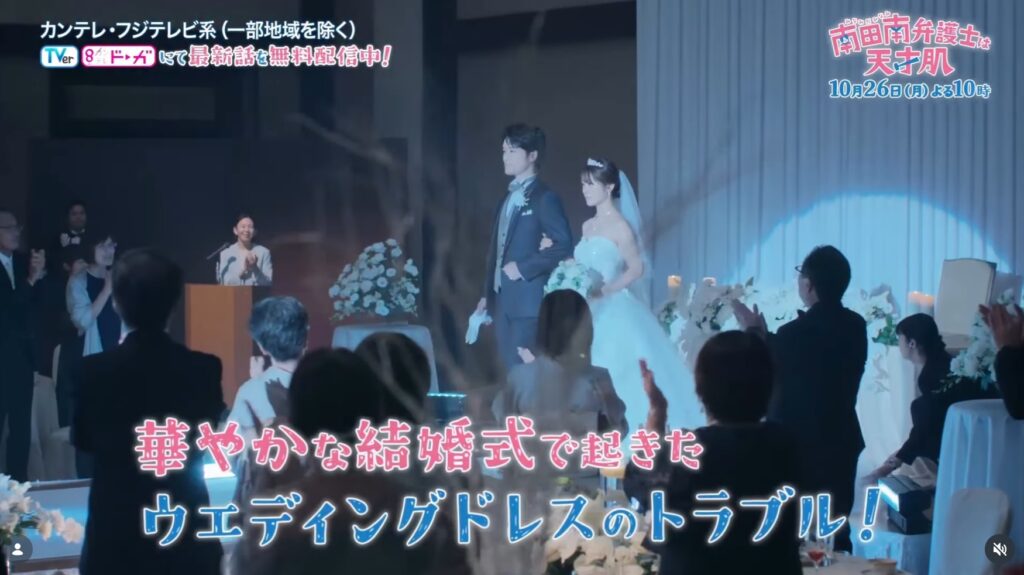 ドラマ『南田南弁護士は天才肌』第2話のワンシーン。ゲストの拍手を受ける中、純白のウェディングドレスを着た花嫁役の渋谷凪咲さんと新郎が腕を組み並んで歩く様子。「華やかな結婚式で起きた」等のテロップが表示されている。