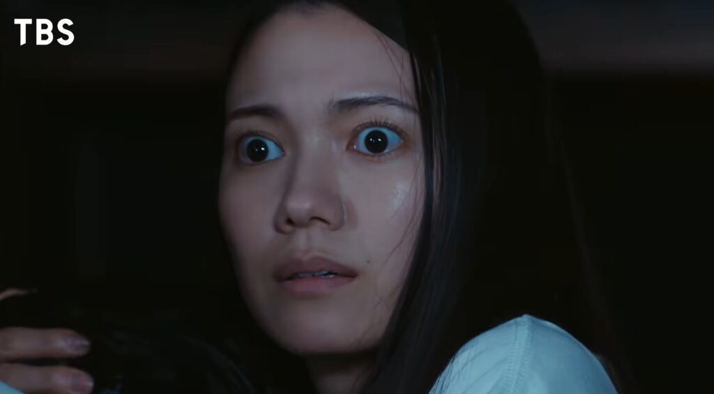ドラマ『VIVANT』のワンシーン。暗がりの中で目を見開き、驚きと恐怖の混ざった表情で相手を見つめる、二階堂ふみさん演じる柚木薫のアップ画像。